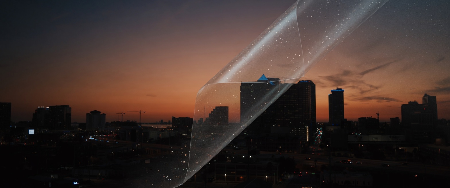 A grain sheet peeling off the dusk skyline while the gradeable picture stays underneath.